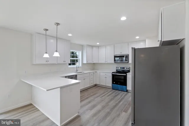 a kitchen with stainless steel appliances a refrigerator sink and stove