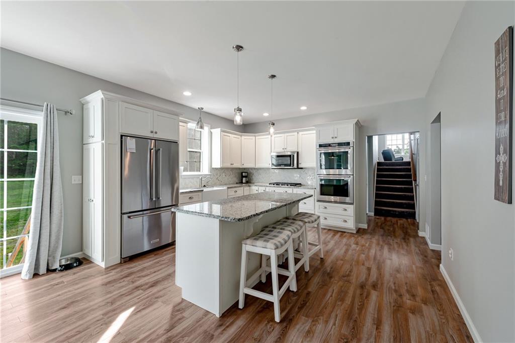 700 Springfield Road Penn Run, PA 15765 - Photo 6 of 25 a kitchen with kitchen island wooden floors white appliances and cabinets