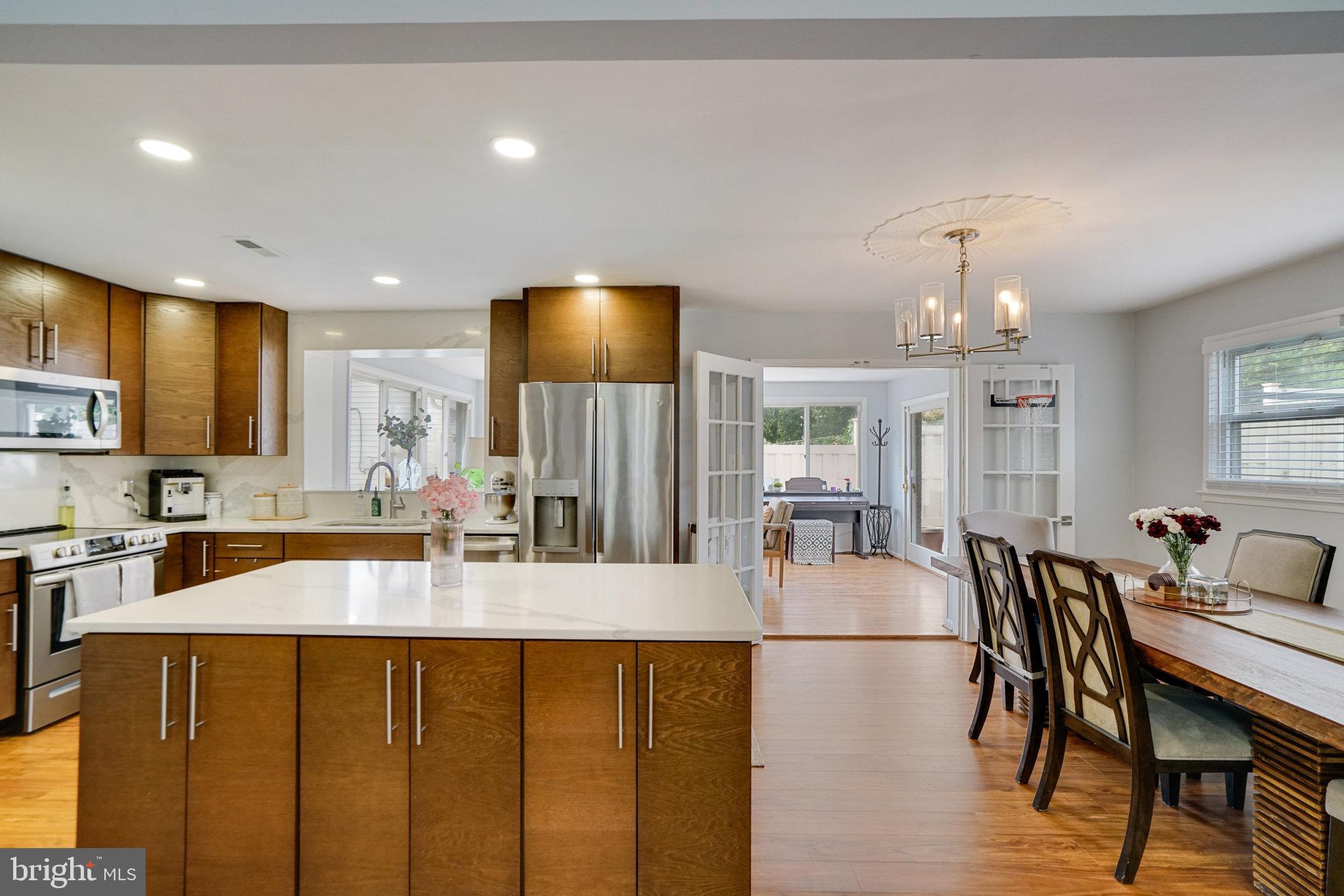 5904 Atteentee Road Springfield, VA 22150 - Photo 18 of 51 a kitchen with stainless steel appliances granite countertop a sink a stove a dining table and chairs