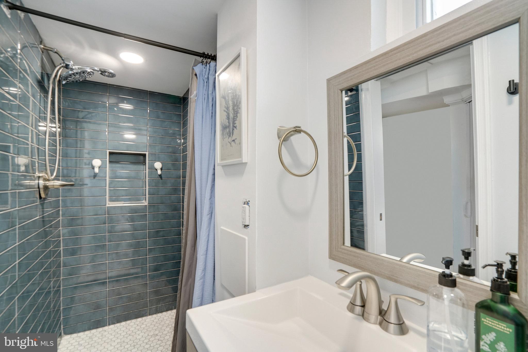 5904 Atteentee Road Springfield, VA 22150 - Photo 41 of 51 a bathroom with a sink a shower and a mirror