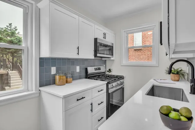 a kitchen with granite countertop a stove a sink and a microwave