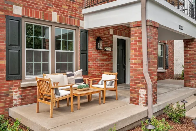 a view of a patio with table and chairs and floor to ceiling window
