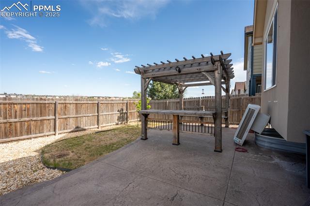 1985 Reed Grass Way Colorado Springs, CO 80915 - Photo 27 of 36 Backyard with stamped concrete, pergola, and fire pit