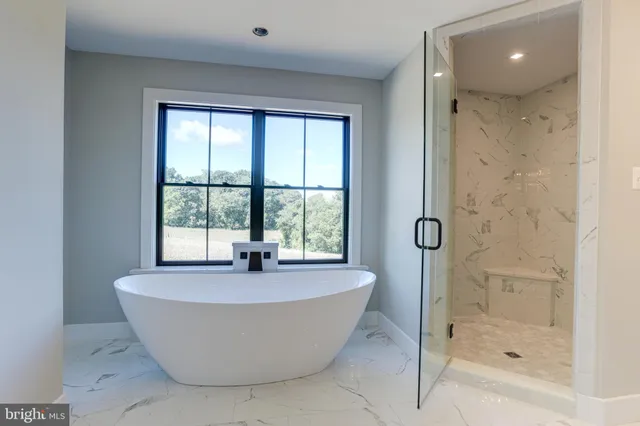 a white bath tub sitting in a bathroom next to a window