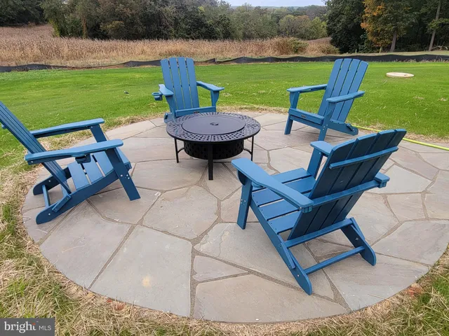 a view of a swimming pool and lounge chairs in back yard of the house