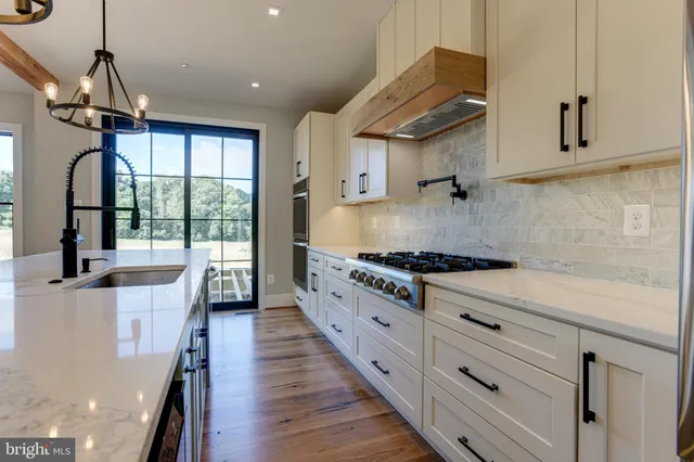 a kitchen with stainless steel appliances granite countertop a stove a sink and a refrigerator