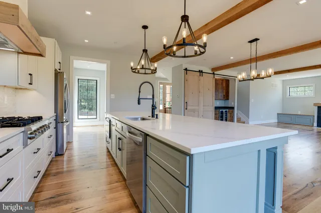 a large kitchen with stainless steel appliances a sink and stove