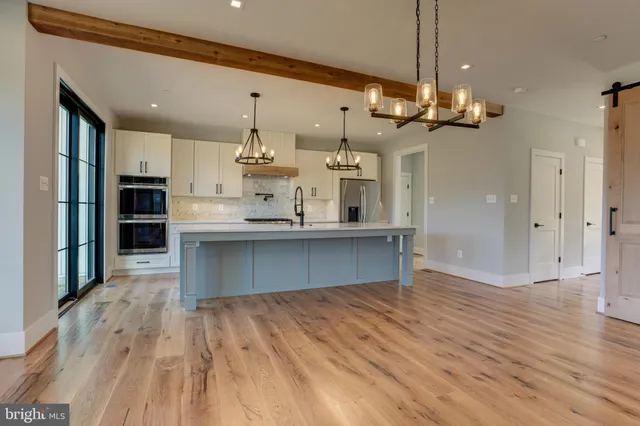 a large kitchen with stainless steel appliances kitchen island a large island in the center and wooden floors