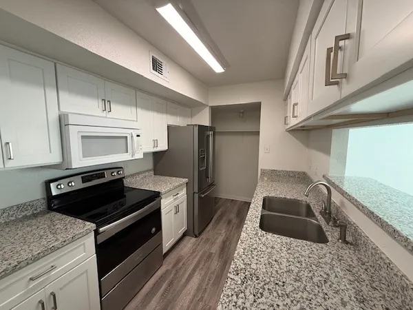 a kitchen with granite countertop a stove and a refrigerator