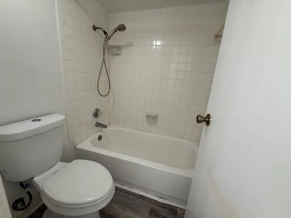a white toilet and tub sitting next to a bathroom sink