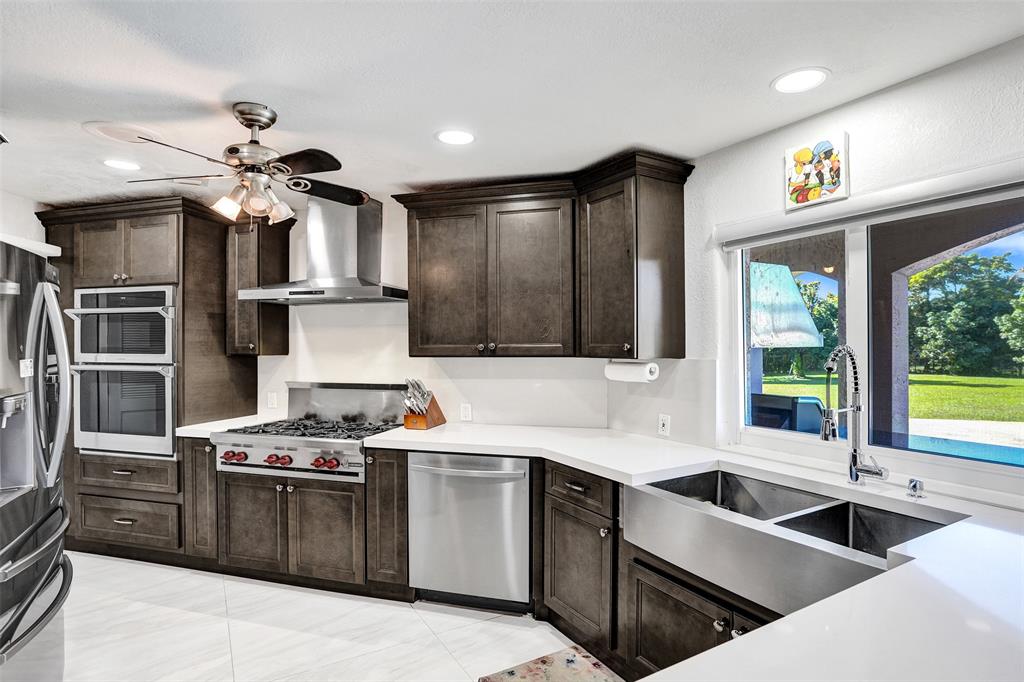 3061 Southwest 117th Avenue Davie, FL 33330 - Photo 17 of 83 a kitchen with stainless steel appliances granite countertop a sink a stove and a refrigerator