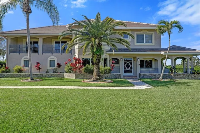 a front view of a house with a yard and potted plants
