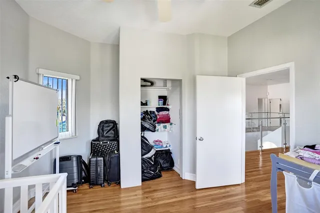 a bedroom with a bed and a flat tv screen on the dresser