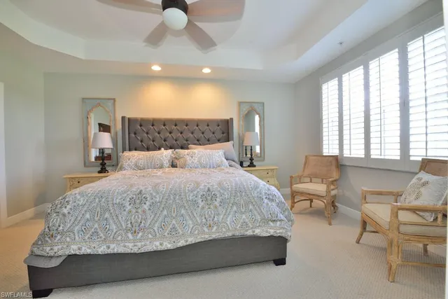 a bedroom with a large bed and a chandelier