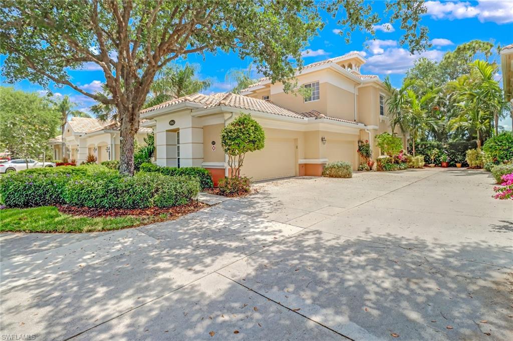 3960 Deer Crossing Court, Unit 6204 Naples, FL 34114 - Photo 2 of 23 a view of a white house with a large trees