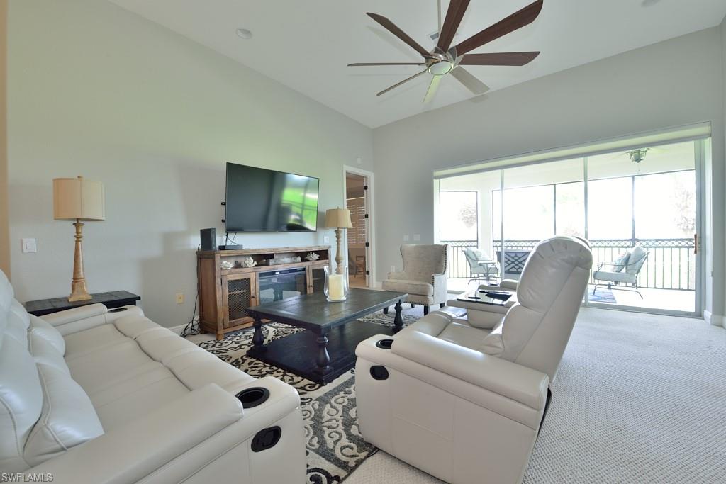 3960 Deer Crossing Court, Unit 6204 Naples, FL 34114 - Photo 7 of 23 a living room with furniture a flat screen tv and a large window