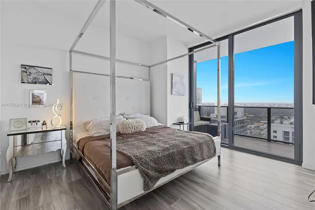 a bedroom with a large bed and a balcony view