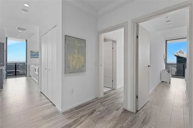 a view of a hallway with furniture and wooden floor