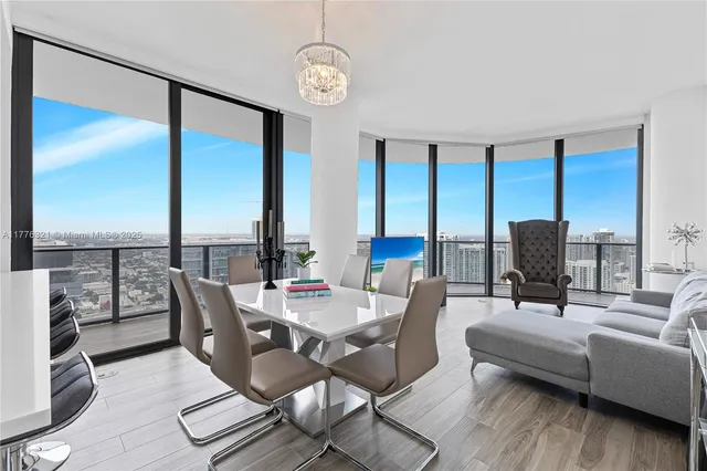 a living room with furniture and floor to ceiling windows