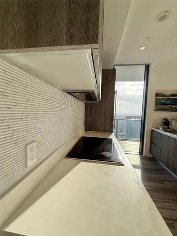 a kitchen with a sink a stove and wooden floor