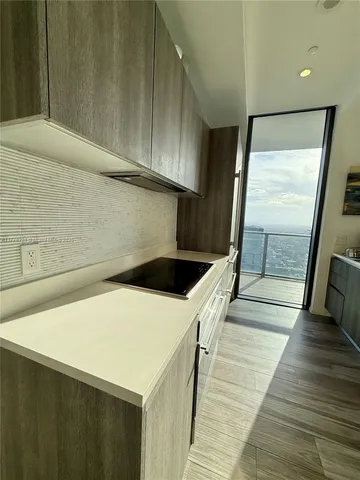 a living room with couch floor to ceiling window and wooden floor