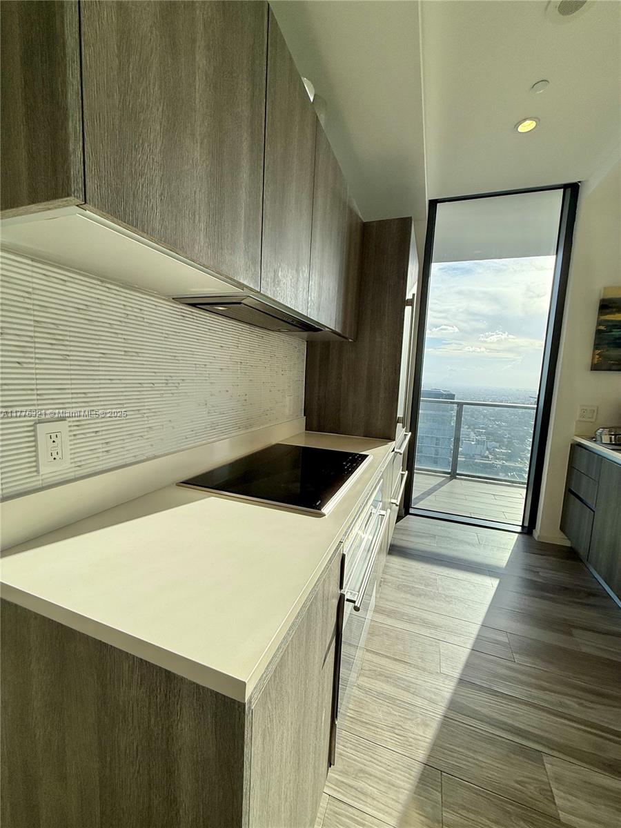 801 South Miami Avenue, Unit 5209 Miami, FL 33131 - Photo 8 of 43 a kitchen with a sink a stove and wooden floor