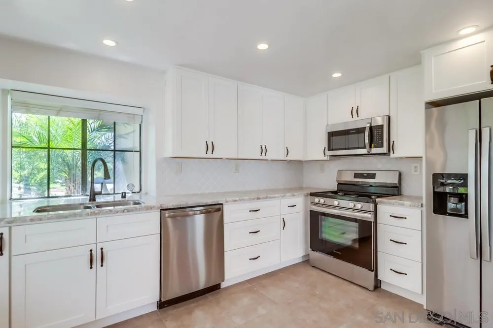 10310 Lake Ridge Court Spring Valley, CA 91977 - Photo 9 of 37 a kitchen with stainless steel appliances granite countertop a stove a sink and a microwave