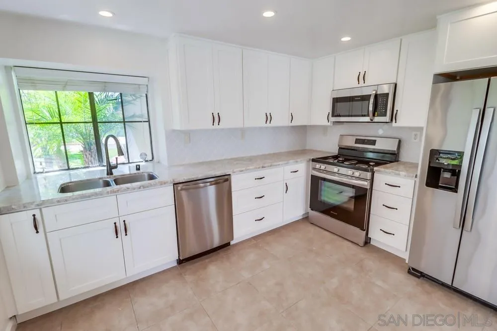 10310 Lake Ridge Court Spring Valley, CA 91977 - Photo 10 of 37 a kitchen with white cabinets appliances and a sink