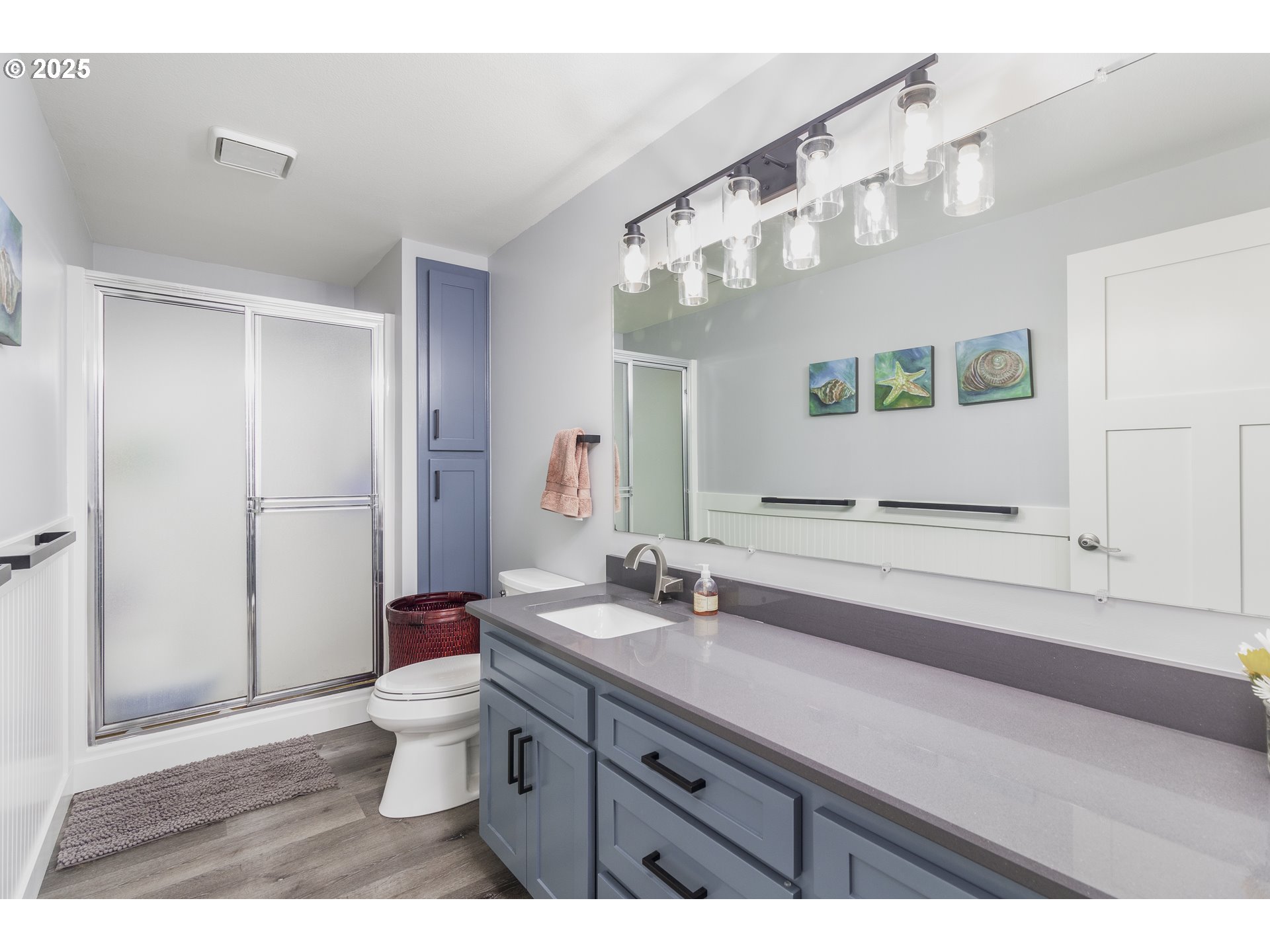 7495 Northeast Neptune Drive Lincoln City, OR 97367 - Photo 15 of 35 a bathroom with a sink a toilet a large mirror and shower