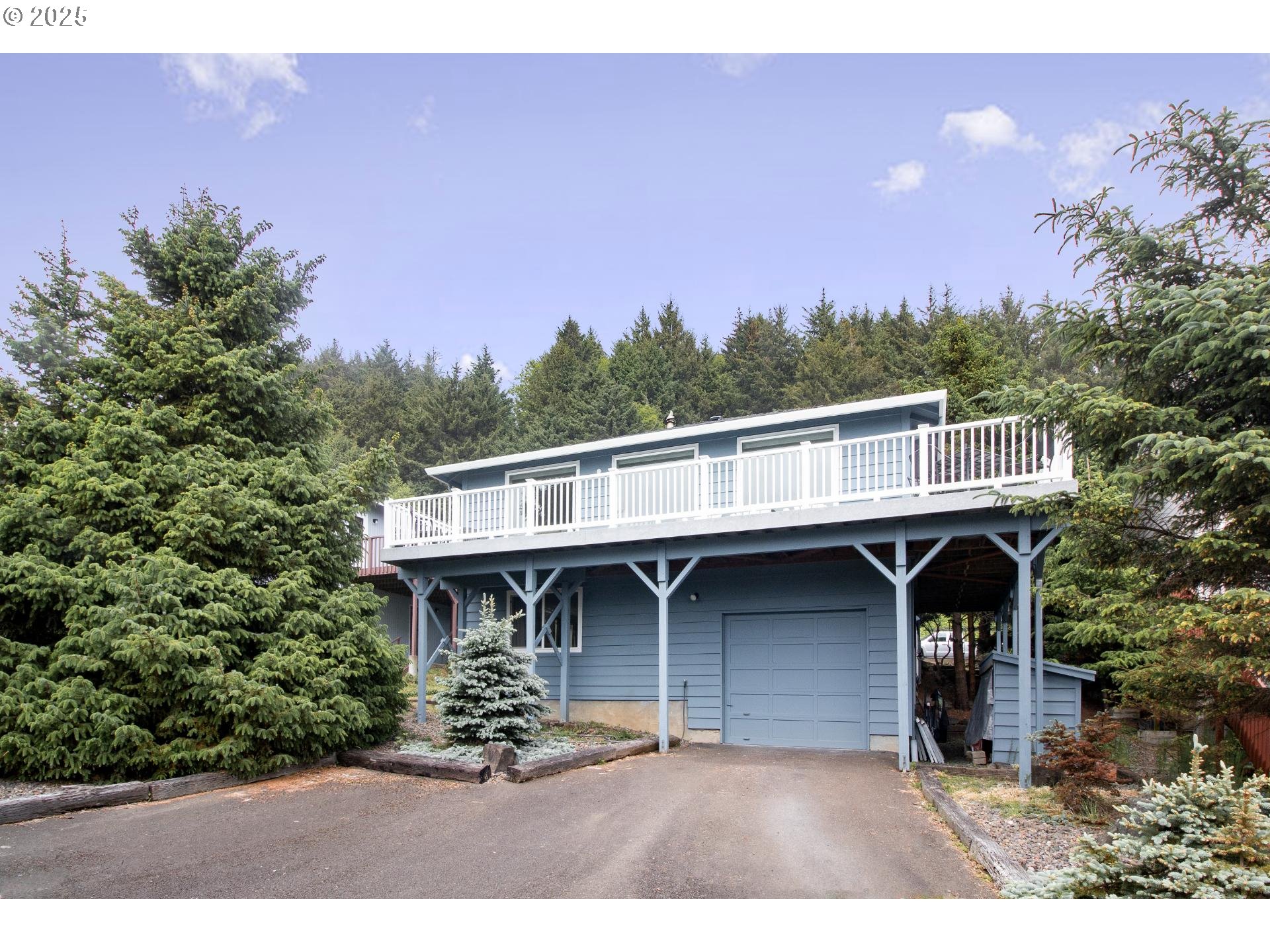 7495 Northeast Neptune Drive Lincoln City, OR 97367 - Photo 2 of 35 a front view of a house with a yard and garage