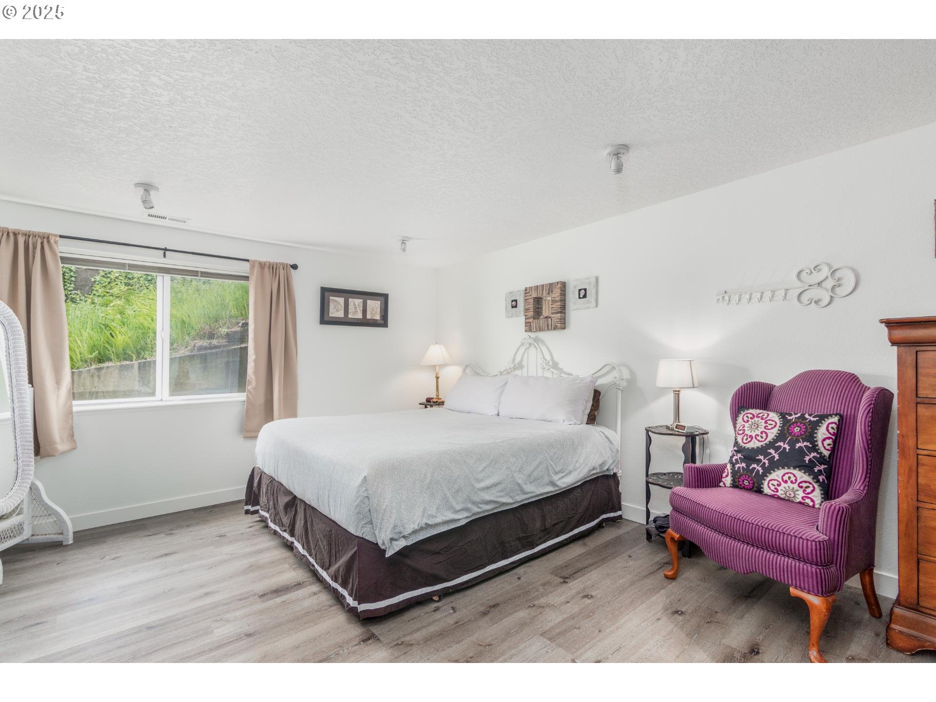 7495 Northeast Neptune Drive Lincoln City, OR 97367 - Photo 21 of 35 a bedroom with a bed and wooden floor