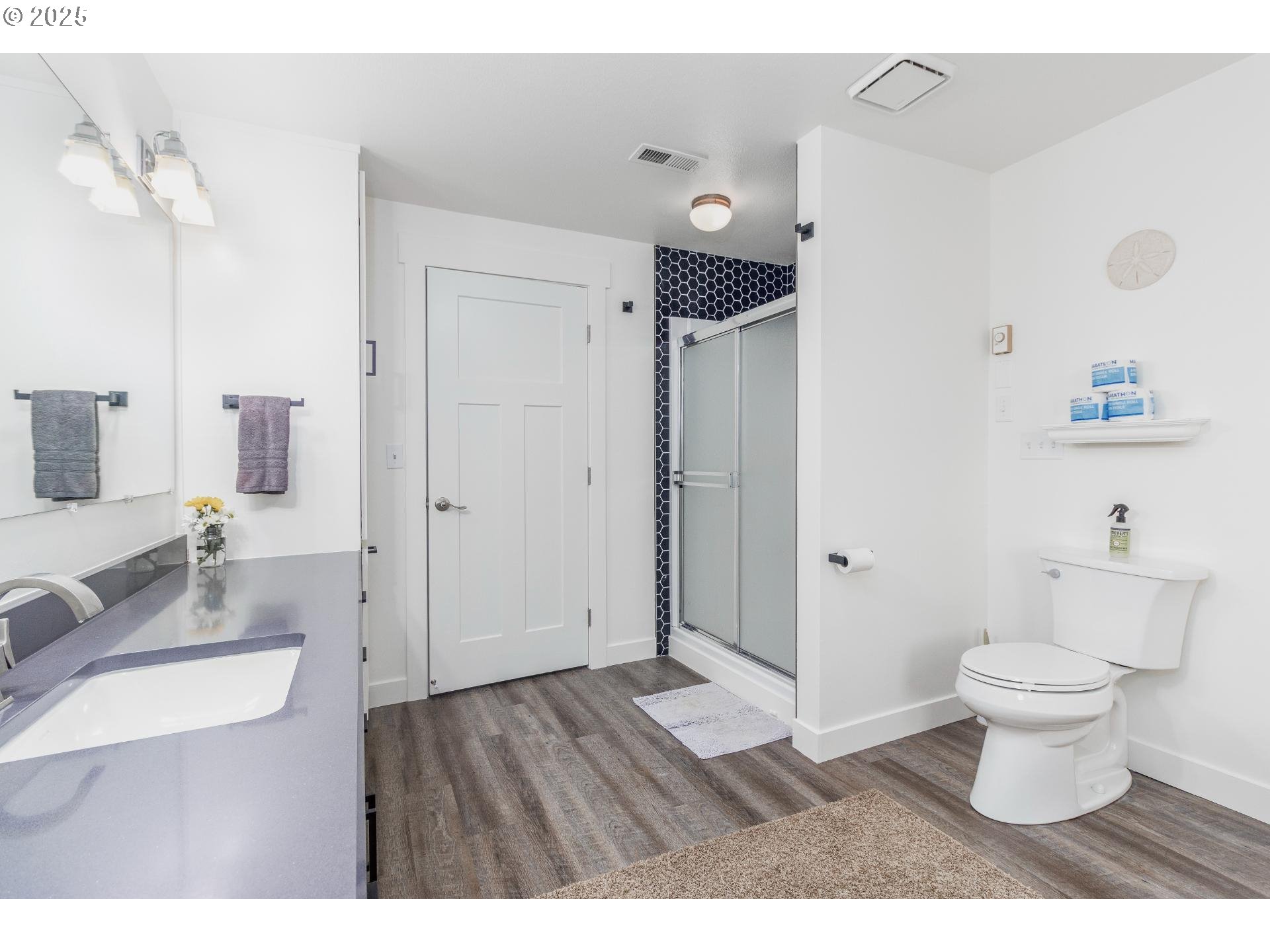 7495 Northeast Neptune Drive Lincoln City, OR 97367 - Photo 22 of 35 a bathroom with a sink toilet a shower and a mirror