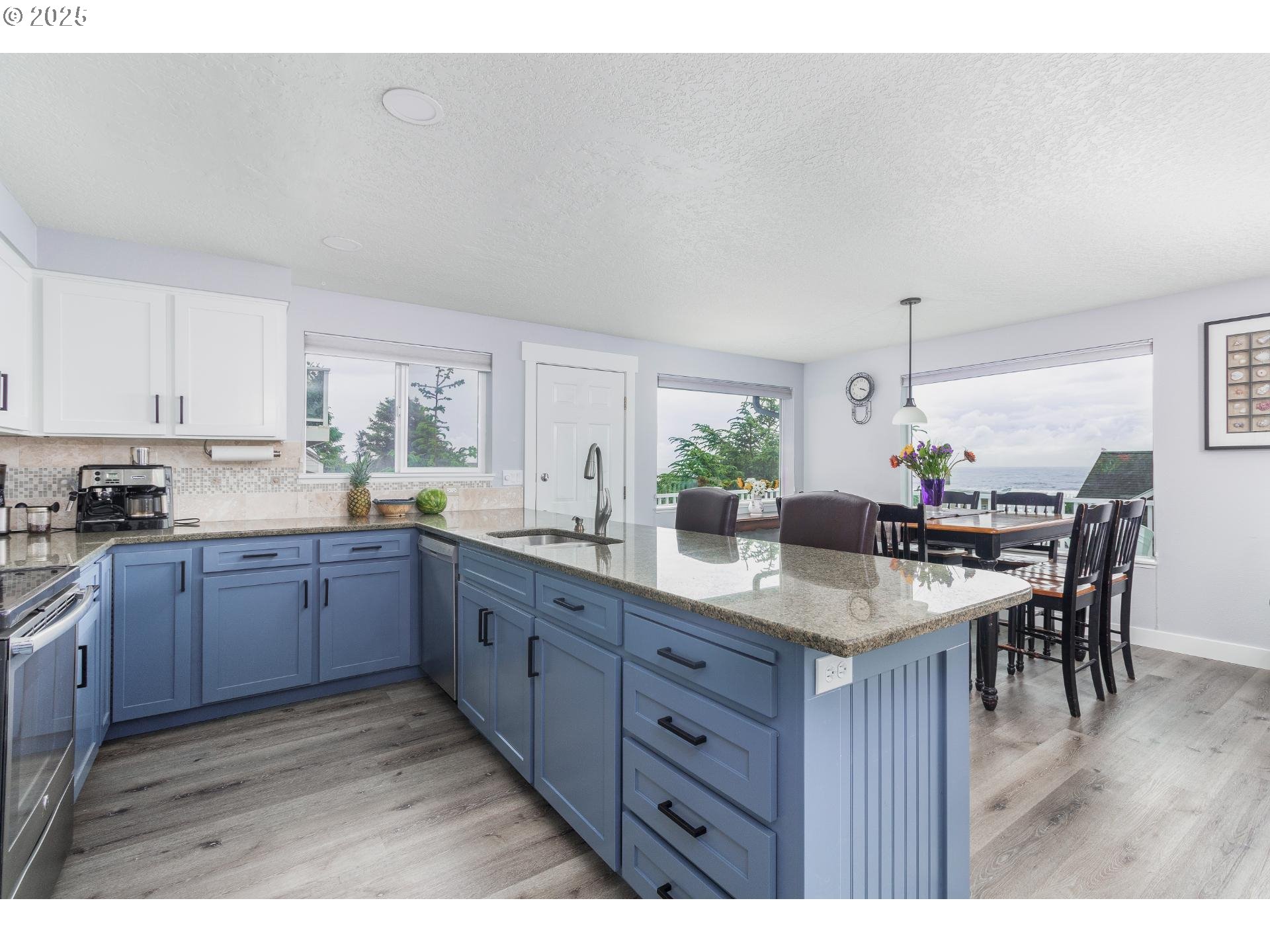 7495 Northeast Neptune Drive Lincoln City, OR 97367 - Photo 10 of 35 a kitchen with granite countertop a table chairs sink and cabinets