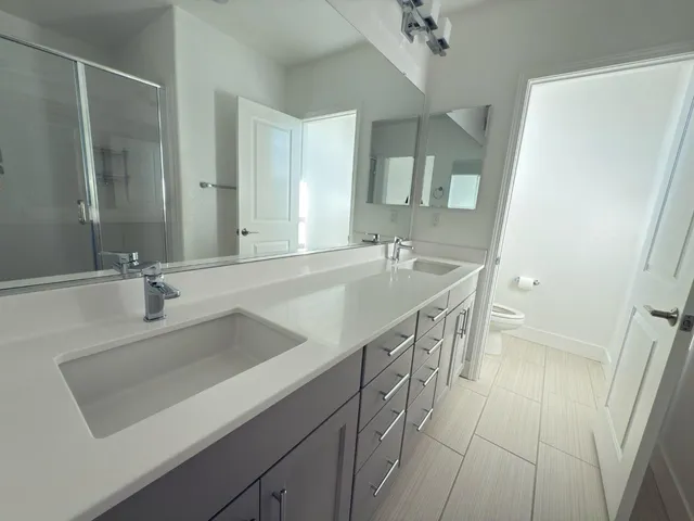 a bathroom with a double vanity sink a mirror and a shower