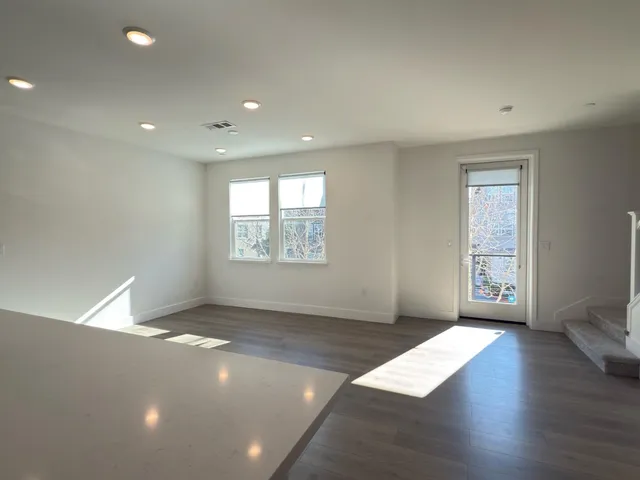 an empty room with wooden floor and windows