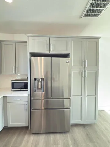 a kitchen with stainless steel appliances wooden floor and cabinets