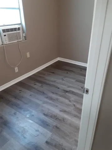 a view of an empty room with wooden floor