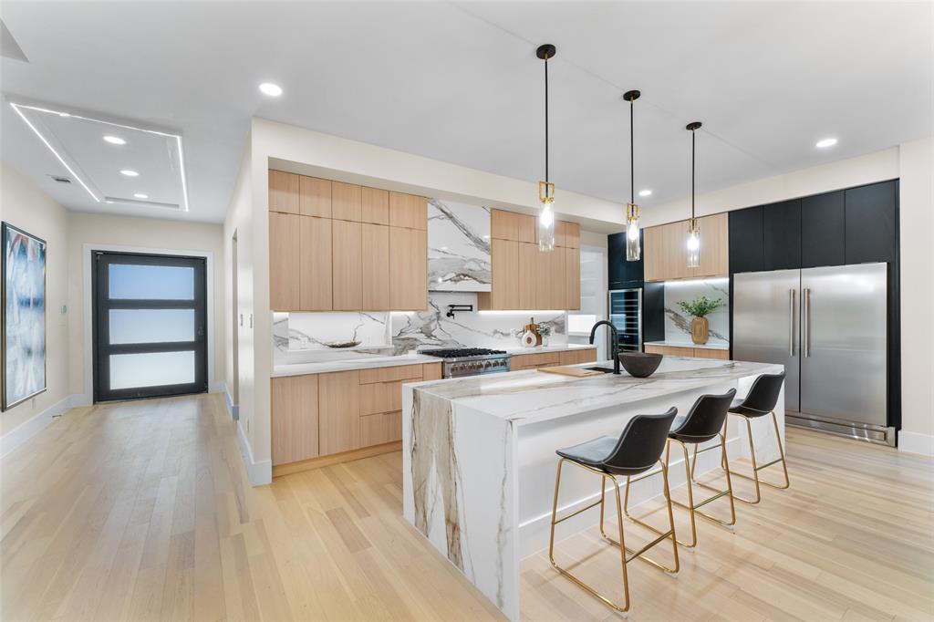 4717 Linnet Lane Dallas, TX 75209 - Photo 4 of 39 a kitchen with stainless steel appliances kitchen island granite countertop a stove a refrigerator and a wooden floor