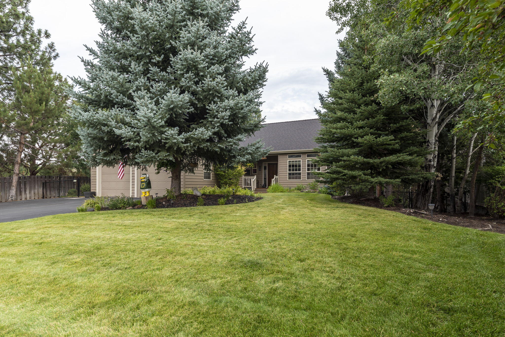 61538 Southeast Hill Ridge Road Bend, OR 97702 - Photo 56 of 59 a front view of a house with a garden and tree