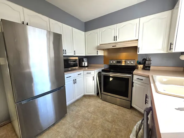 a kitchen with stainless steel appliances a refrigerator sink and cabinets