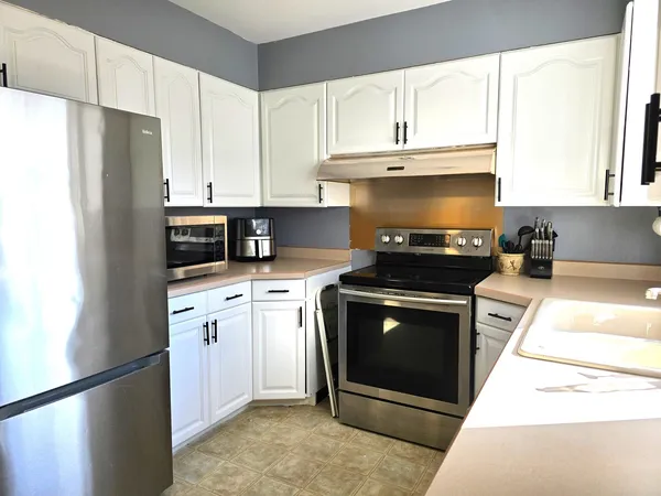 a kitchen with stainless steel appliances granite countertop a stove a refrigerator and a sink