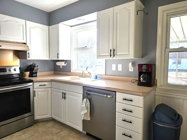a kitchen with stainless steel appliances granite countertop a sink a stove and cabinets