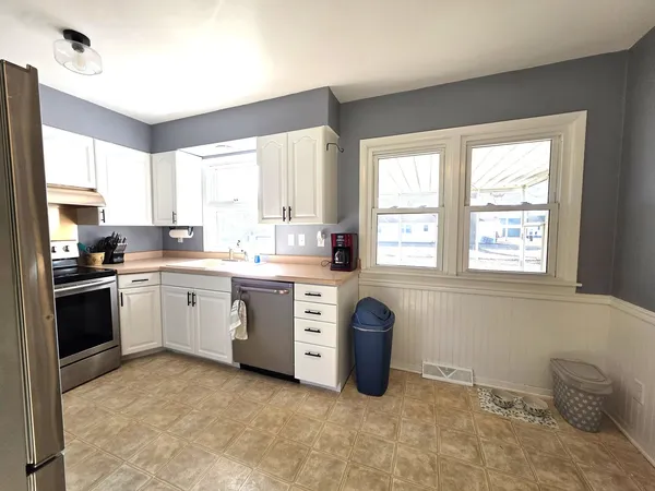 a kitchen with a stove a sink and a window