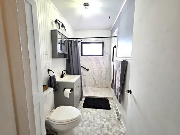 a white toilet sitting next to a bathroom sink and a mirror