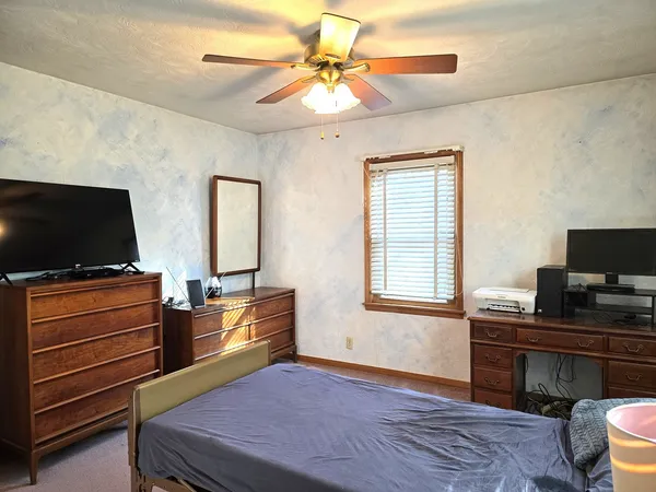 a bedroom with furniture and a flat screen tv