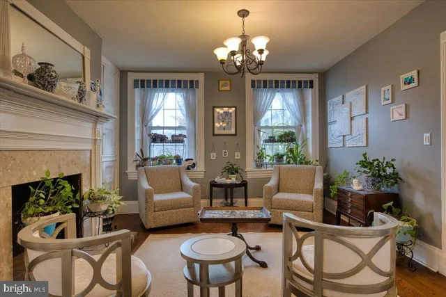 a living room with furniture a chandelier and a fireplace