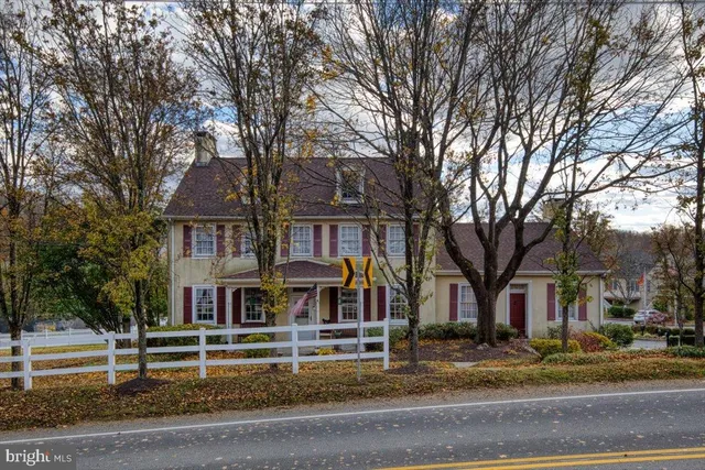 a front view of residential houses with yard and trees