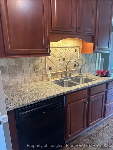 a kitchen with granite countertop a sink and cabinets