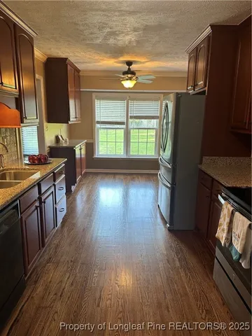 a view of a kitchen with wooden floor and electronic appliances