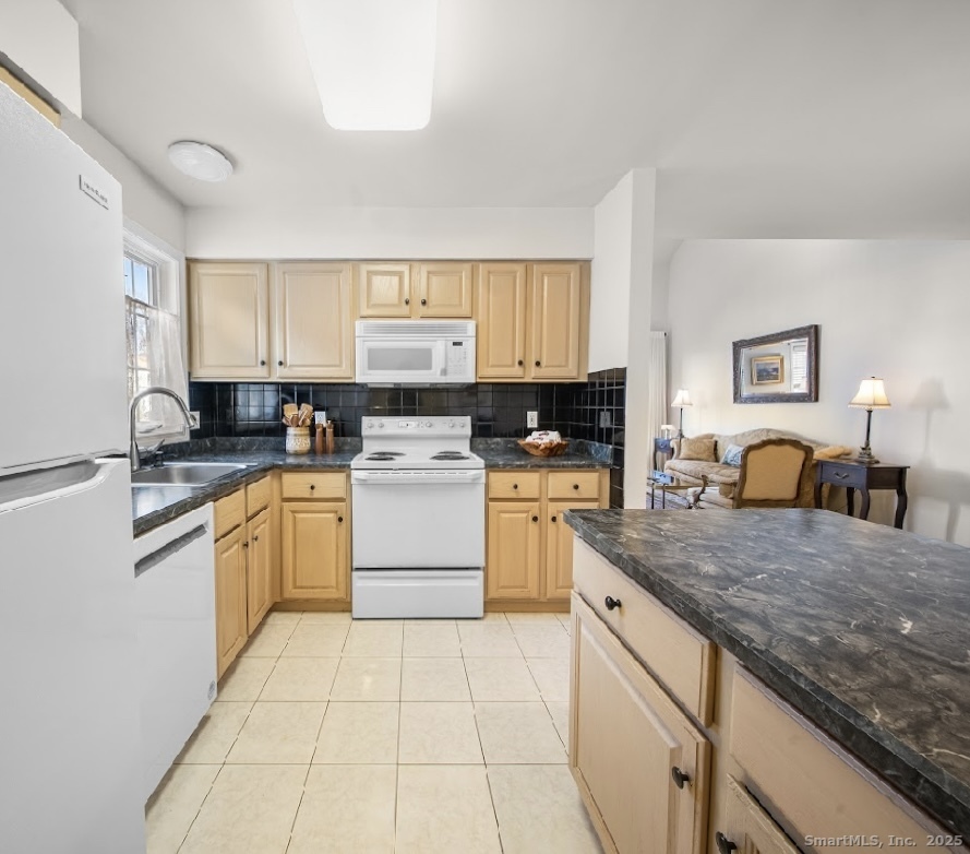 91 Forest Road, Unit B Milford, CT 06461 - Photo 15 of 28 a kitchen with kitchen island granite countertop white cabinets sink and white appliances